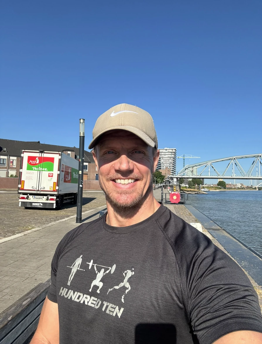 Sjoerd smiling outdoors in a cap, by the water